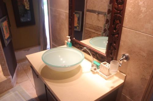 a bathroom with a glass sink in front of a mirror at mame trees in West End