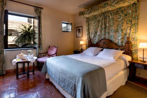 A bed or beds in a room at Parador de Jarandilla de la Vera