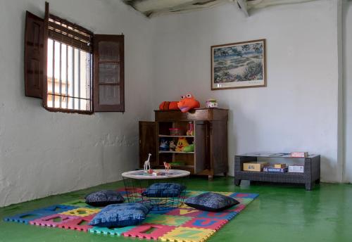 a room with a table and two chairs on a green floor at Alojamiento Turistico La Casa del tio Cesar in Cañas