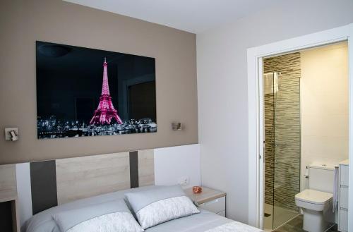 a bedroom with a bed with a picture of the eiffel tower at Alojamiento Turistico La Casa del tio Cesar in Cañas