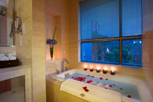 a bathroom with a tub with red flowers in it at Huachen International Hotel in Hangzhou