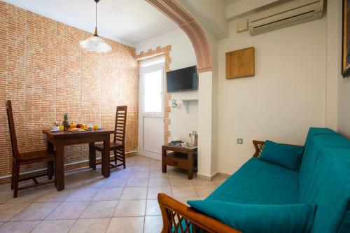 a living room with a blue couch and a table at Kastro Apartments in Panormos Rethymno