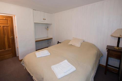 een slaapkamer met een bed waarop twee handdoeken liggen bij El Tero in Bariloche