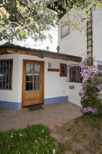 een huis met een houten deur en een boom bij El Tero in Bariloche