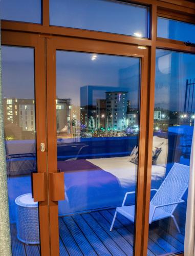 a balcony with a bed and a view of a city at Villare Leicester City Centre hotel in Leicester