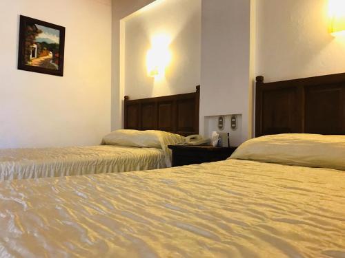 a hotel room with two beds in a room at Hotel La Mansión in San José Iturbide