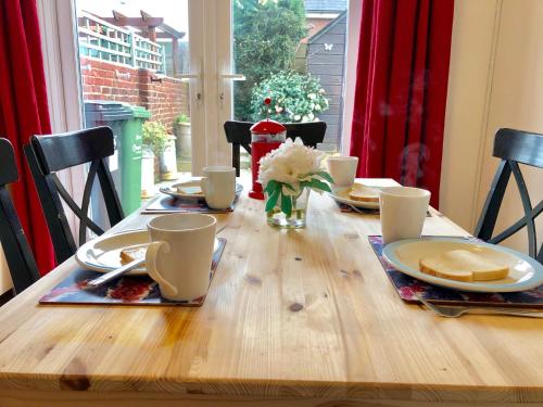 a wooden table with plates and dishes on top of it at Little Connaught 2 bed House pet friendly in Portsmouth