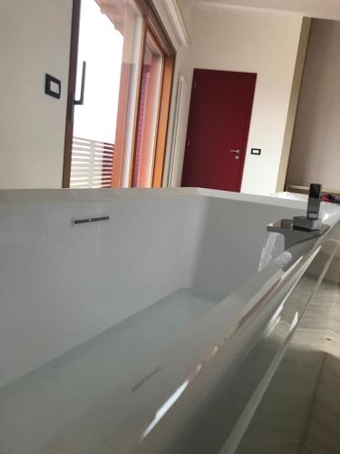 a mirror in a white room with a sink at Agritur Verderame in Trento