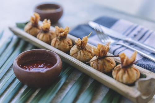 a plate of food with dipping sauce on a table at Mezzanine a Colibri Boutique Hotel-Adults Only in Tulum