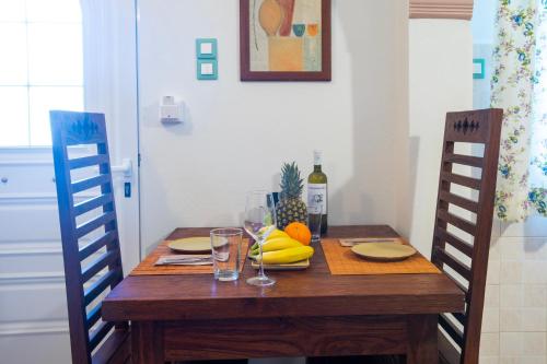 a wooden table with fruit and a bottle of wine at Kastro Apartments in Panormos Rethymno