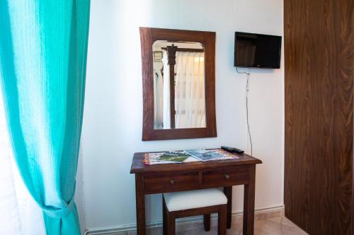 a room with a table with a mirror and a chair at Kastro Apartments in Panormos Rethymno