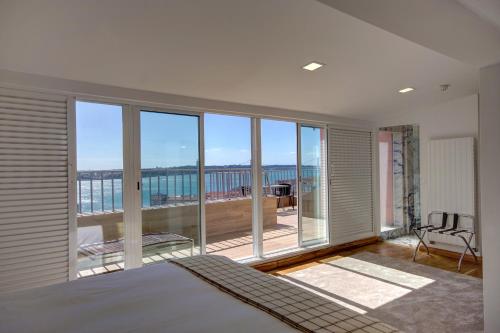 a bedroom with a large window with a view of the ocean at Solar Dos Mouros in Lisbon