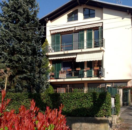 uma casa branca com uma varanda e uma árvore em Alla Ghigliotta em Viverone