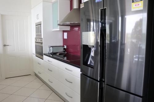 a kitchen with a stainless steel refrigerator at River Devine in White Sands
