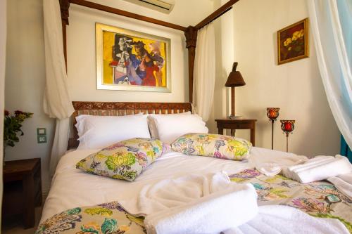 a bedroom with a white bed with pillows at Kastro Apartments in Panormos Rethymno