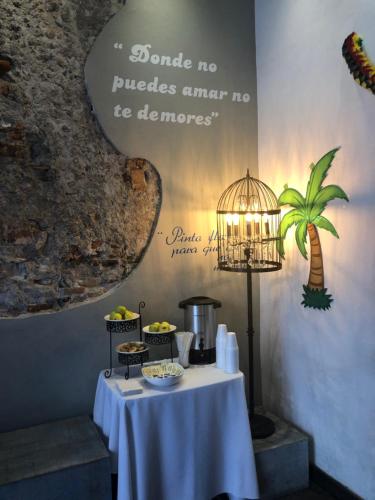 a table with a white table cloth and a bird cage at Hotel Frida in Puebla