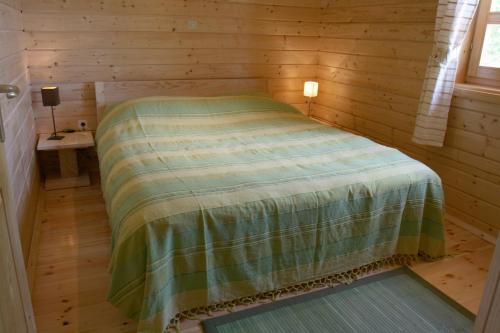 a bedroom with a bed in a wooden cabin at Ranch Jelov Klanac in Rakovica