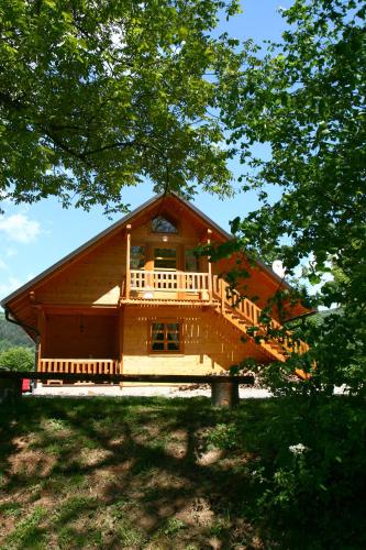 a large wooden house with a balcony on a hill at Ranch Jelov Klanac in Rakovica