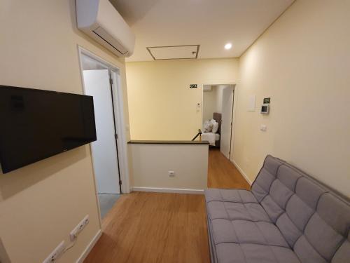 a living room with a couch and a flat screen tv at Agnelo Comfort - Accommodation H V in Funchal
