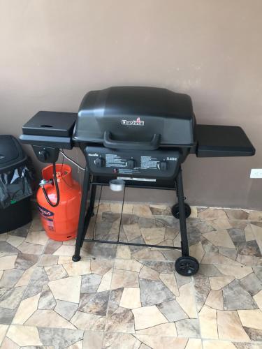 a charcoal grill on a stand with a bucket at Aprtamento Deluxe Santiago, Residencial Palma Real R402 in Santiago de los Caballeros