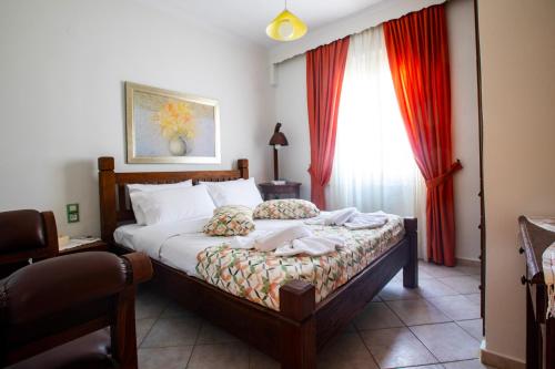 a bedroom with a bed and a window with red curtains at Kastro Apartments in Panormos Rethymno