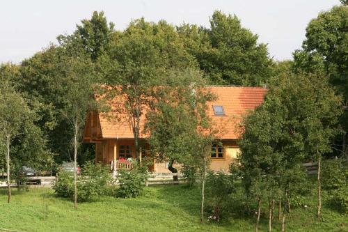 a house with a red roof in the middle of trees at Ranch Jelov Klanac in Rakovica