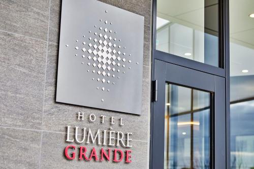 a sign on the facade of a hotel winner grande at Hotel Lumiere Grande Nagareyama-Otakanomori in Nagareyama