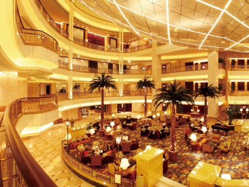 a large building with a lobby with palm trees at Grand Central Hotel Shanghai in Shanghai