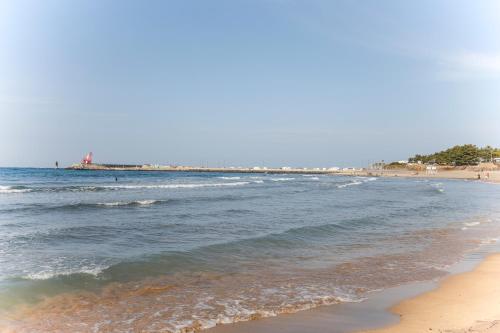 a beach with the ocean and people in the water at Jeju Ocean Family Hotel in Jeju