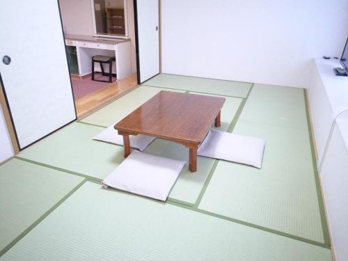 a wooden floor with a rug on top of it at U-Community Hotel in Osaka