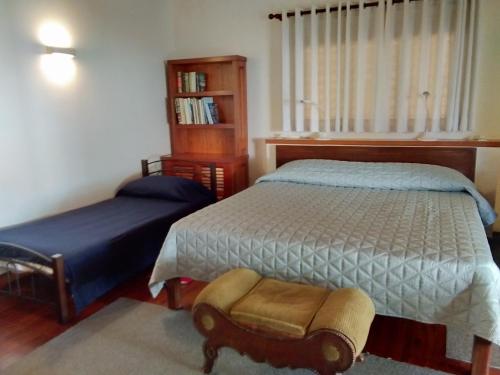 a bedroom with two beds and a book shelf at Ancelle Cristo Re in Moalboal