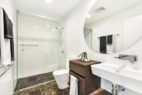 a bathroom with a sink toilet and a mirror at Qube Broadbeach Ocean View Apartments in Gold Coast