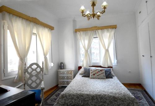 アテネにあるAthens Apartmentのベッドルーム1室(シャンデリア、窓付)