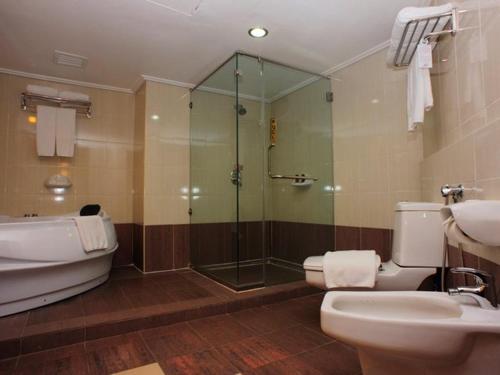 ein Bad mit einer Dusche, einem WC und einem Waschbecken in der Unterkunft Primula Beach Hotel in Kuala Terengganu