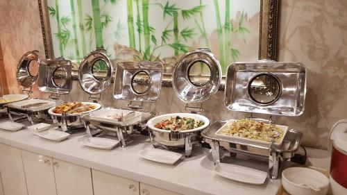 a buffet with several dishes of food on a counter at Amour Hotel in Suwon