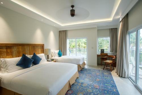 a hotel room with two beds and a large window at Cove Resort Palau in Koror