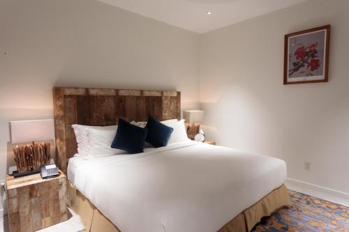 a bedroom with a large white bed with blue pillows at Cove Resort Palau in Koror