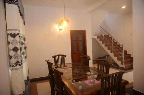 a dining room with a glass table and chairs at Nimnada Villa in Galle