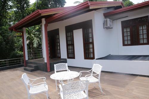 a patio with chairs and a table and a building at Nimnada Villa in Galle