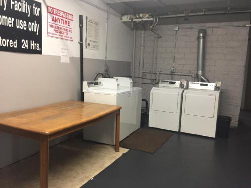 a laundry room with two washers and a wooden table at Motel express in Everett