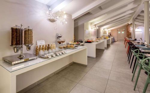 a restaurant with a long line of counters and chairs at Best Western Plus Royal Superga Hotel in Cuneo