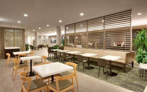 a restaurant with tables and chairs and plants at Hyatt House Portland / Downtown in Portland