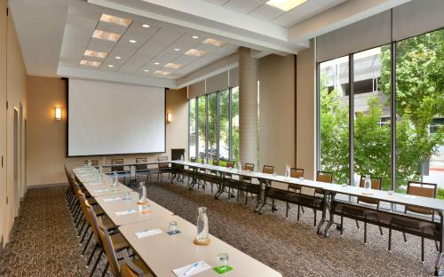 a conference room with long tables and a screen at Hyatt House Portland / Downtown in Portland