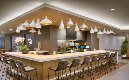 a lobby with a bar with chairs and lights at Hyatt House Portland / Downtown in Portland