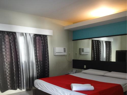 um quarto com uma cama com um cobertor vermelho em Heilee's Guest House em General Santos