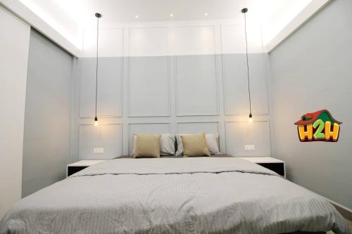 1 dormitorio con 1 cama grande y paredes blancas en H2H - Sweet Cottage - Octagon en Ipoh