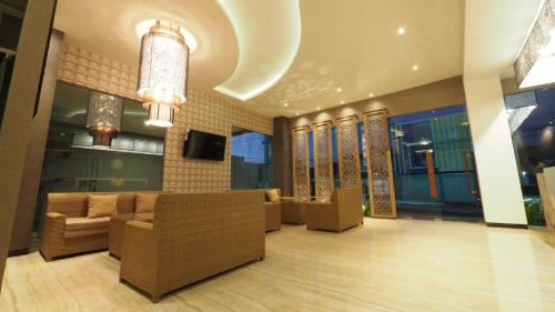 a lobby with couches and a tv in a building at De Boutique Style Hotel in Malang