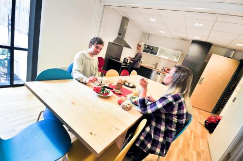 a man and a woman sitting at a table in a kitchen at Stavanger St Svithun Vandrerhjem in Stavanger