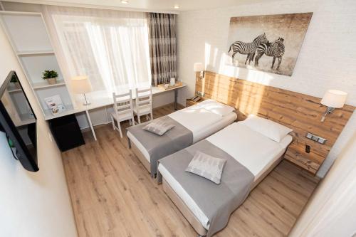 En eller flere senge i et værelse på Dvina Hotel