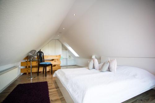 1 dormitorio en el ático con 1 cama y 1 silla en Ferienwohnungen in Wremen, en Wremen